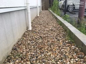 自然石の風合いが華やかに彩り雑草対策する犬走り[施工後]