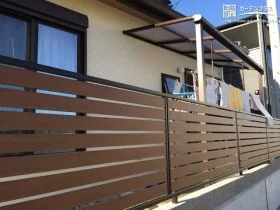 落ち着いた色合いがお住いをシックに演出するテラス屋根と目隠しフェンス[施工後]