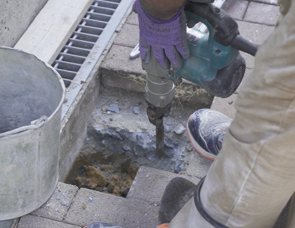 カーポートの基礎を斫る様子