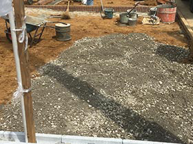 土間コンクリート沈下防止のための砕石を搬入・敷設している様子