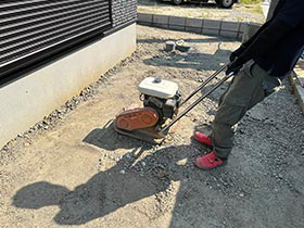 土間コンクリート沈下防止のために敷いた砕石を転圧機で押し固める様子